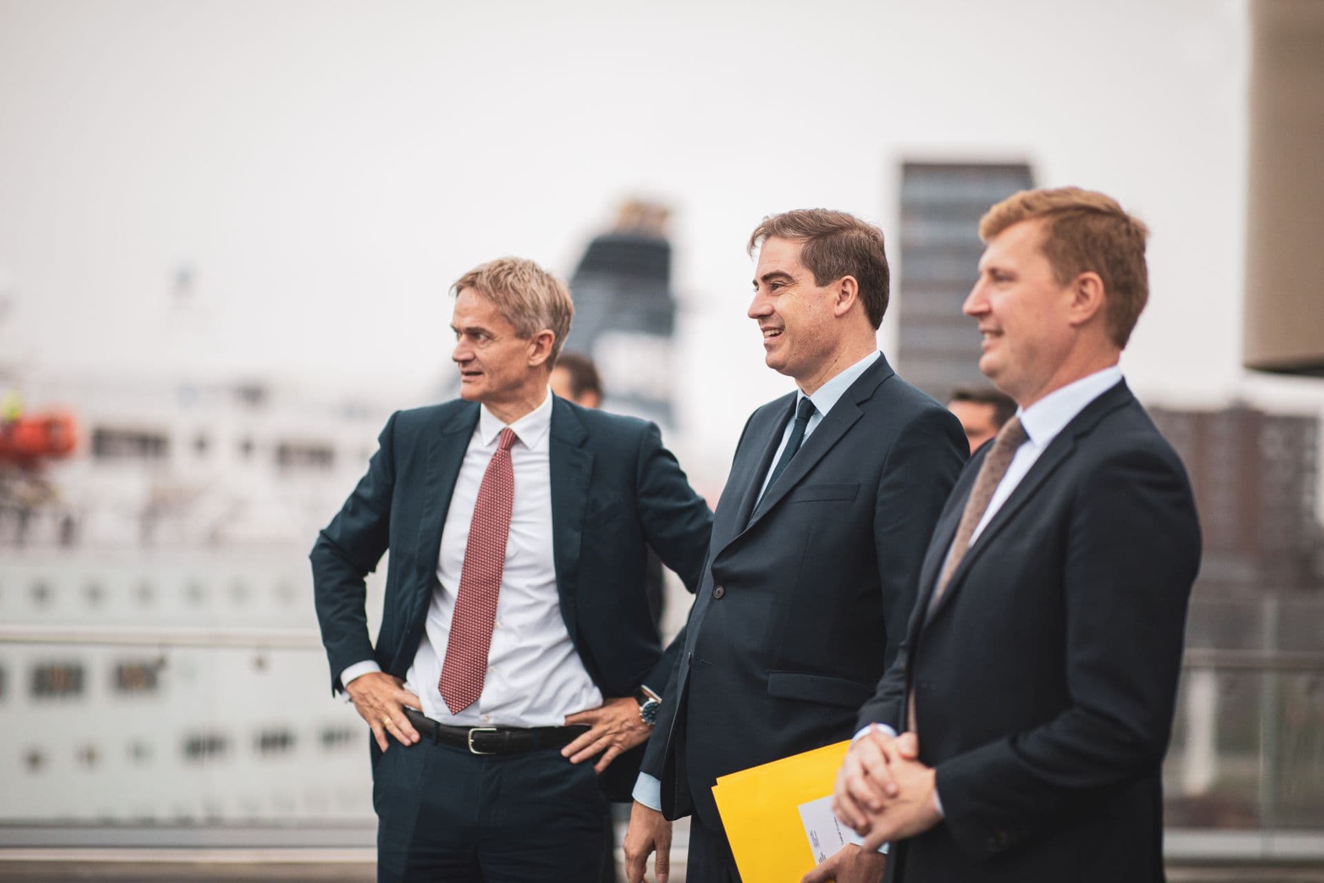 Featured article picture with news article, depicting from left to right CEO Torben Carlsen, French Minister Olivier Becht and Mathieu Girardin, at the background a DFDS vessel