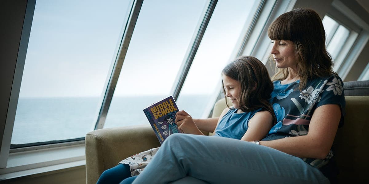 Woman and little girl reading a book onboard Eastern Channel Ferry