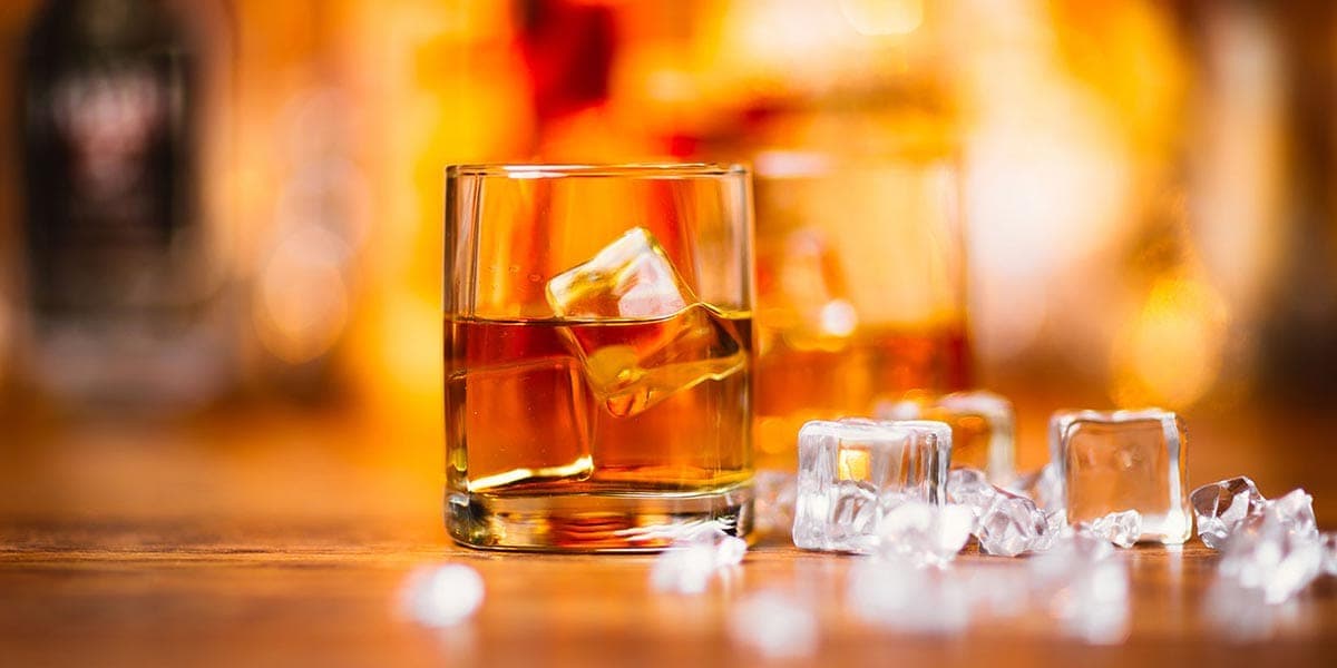 Glass of whisky with ice cubes