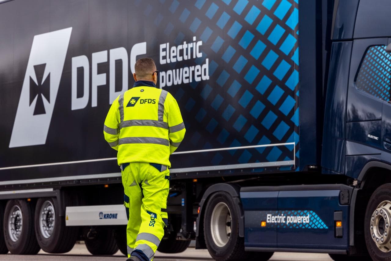 A DFDS worker walking towards an electric truck.
