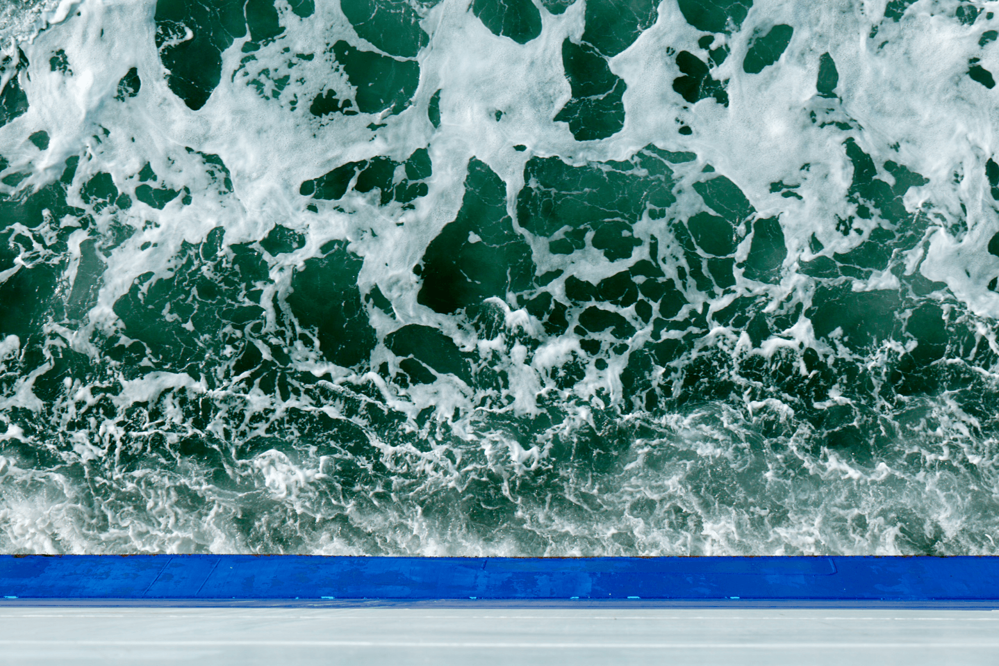 Foam-tipped waves swirling around a DFDS vessel